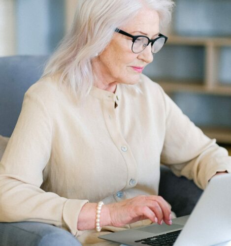 older woman works on a laptop