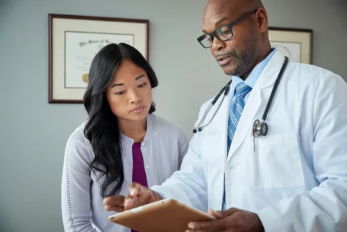 doctor shows woman ipad in office