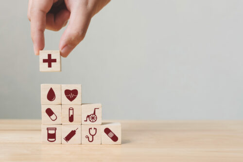 hand stacking medical themed blocks