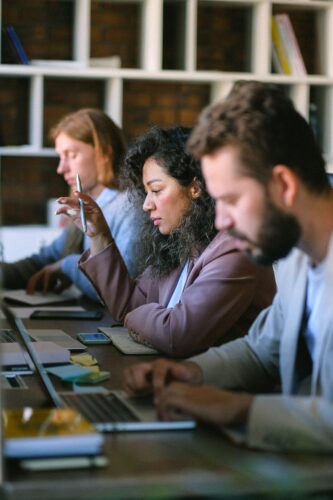 woman at a computer with other people in the foreground