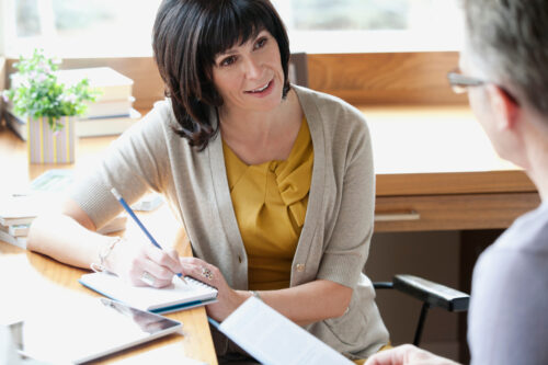 Nice woman taking notes while interviewing a man