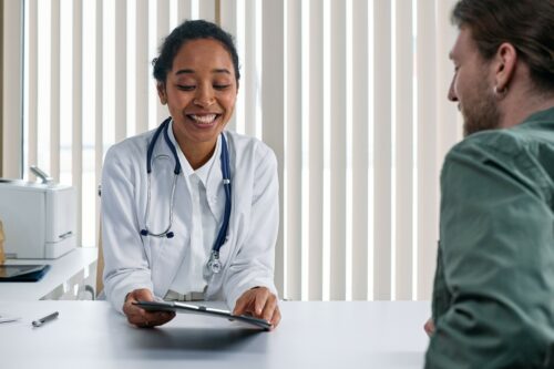 doctor consults with a patient in foreground