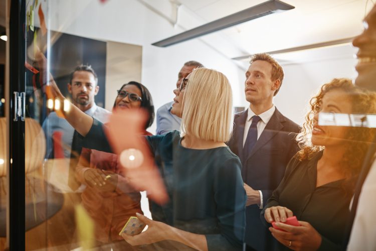 Group of diverse office colleagues brainstorming together with s