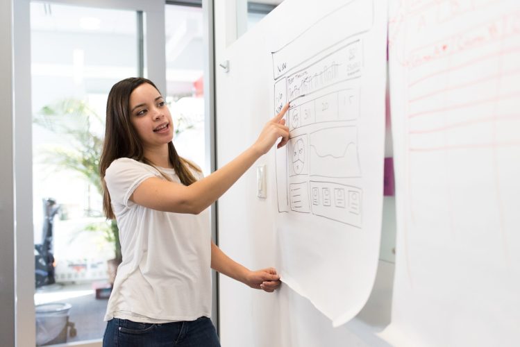 woman pointing to notes on a board