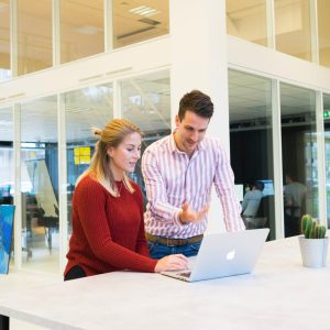 female and male employees looking at a laptop