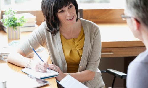 Nice woman taking notes while interviewing a man