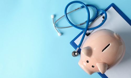 Stethoscope and piggy bank on blue background, space for text