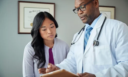 doctor shows woman ipad in office