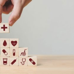 hand stacking medical themed blocks