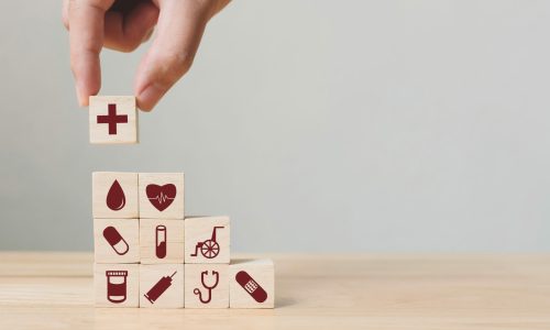 hand stacking medical themed blocks