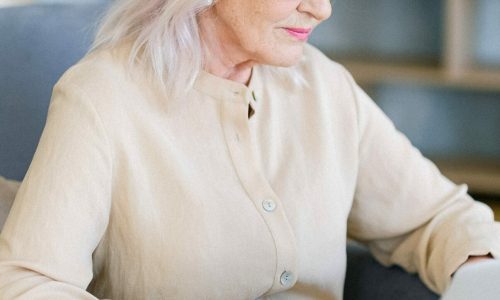 older woman works on a laptop